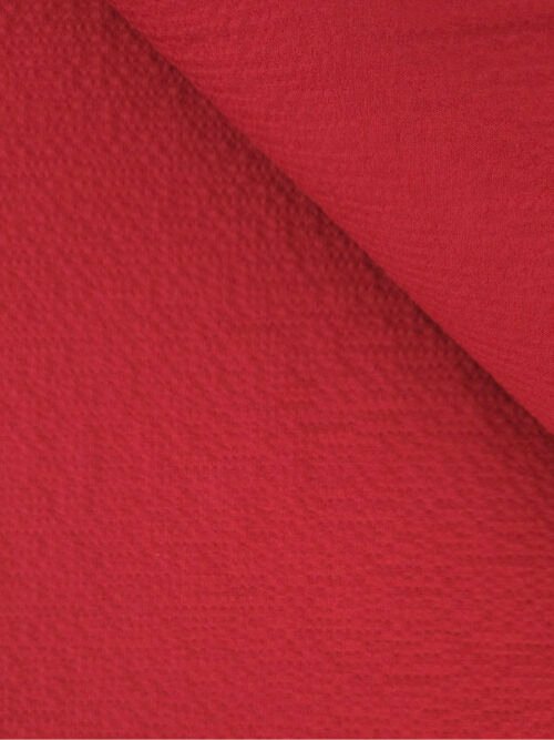 Zoom sur la texture gaufrée du seersucker rouge tomette