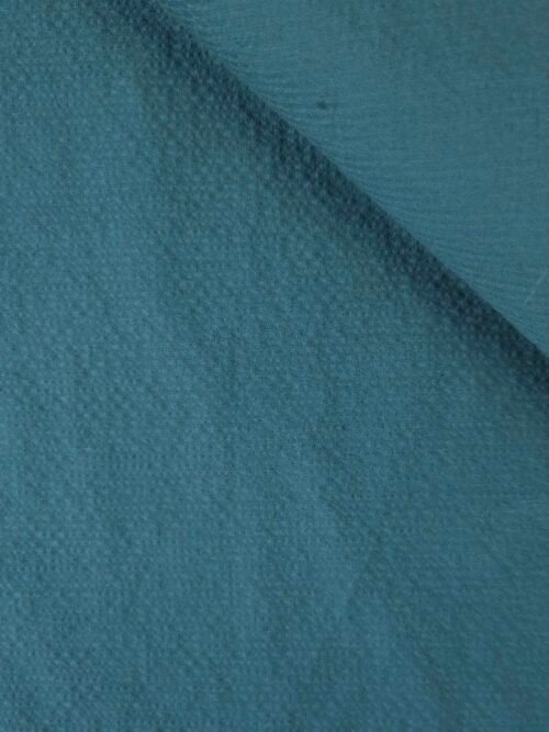 Zoom sur la texture ondulée du tissu seersucker bleu pétrole