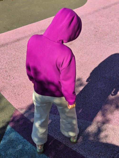 Vue de dos d’un sweat à capuche fuchsia sur fond rose ; patron sweat femme Bauhaus.