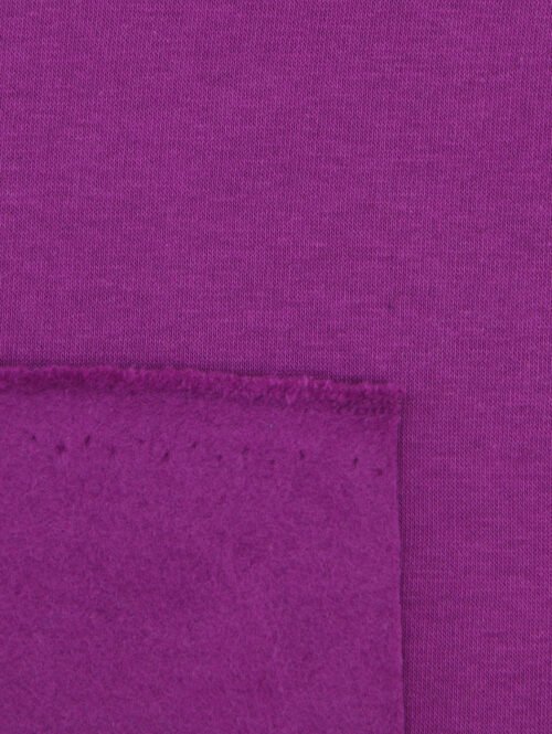 Vue rapprochée de l’endroit maille et de l’envers gratté du tissu molleton fuchsia (280 g/m²).